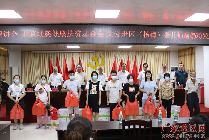 图为化州市老区杨梅镇受助家长代表领取捐赠奶粉.JPG