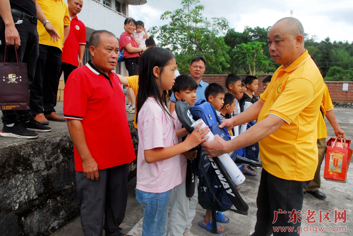 闲土娇会长向学生们送上书包和羽毛球拍.JPG
